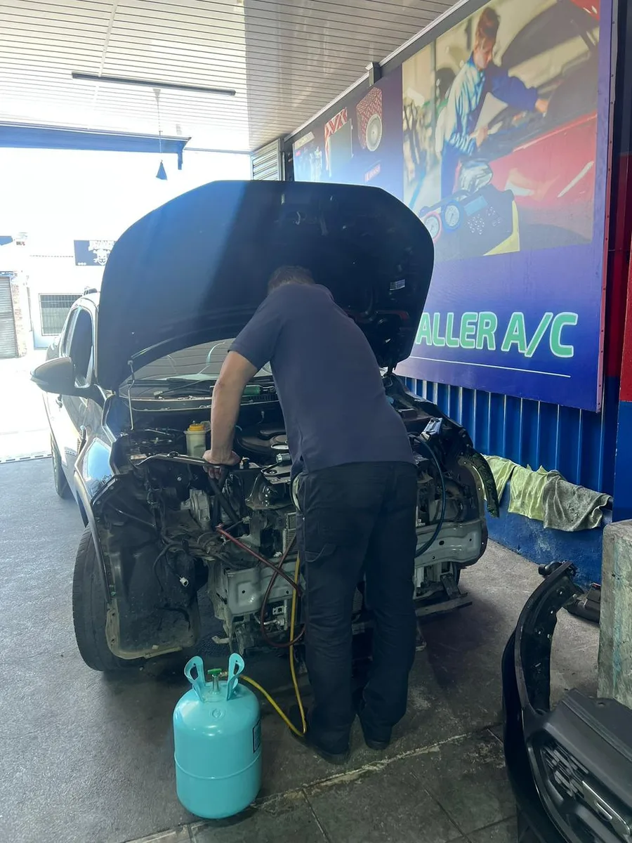 Técnico trabajando en un vehículo en Aire Acondicionado Charly